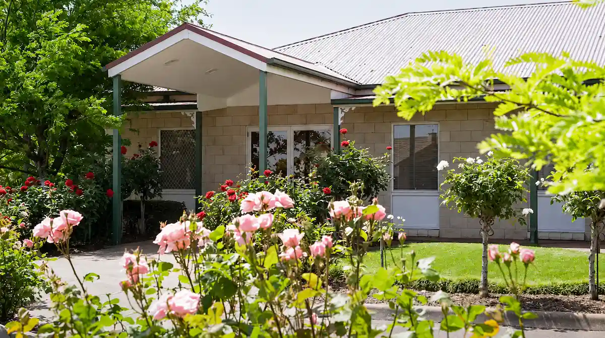 Exterior of Jonathan Hepner Funerals, a peaceful funeral home in Geelong surrounded by lush green lawns and blooming rose gardens.