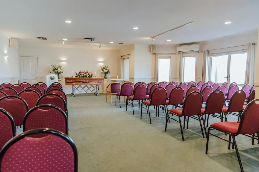 Full interior view of the East Geelong Small Chapel showing rows of burgundy chairs set up for intimate funeral services at 199 Ormond Rd, East Geelong.