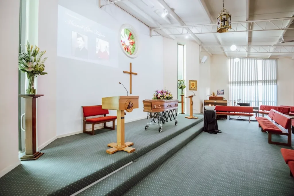 Angled interior view of the spacious sanctuary stage showing the speaker lectern, high-definition projection screen, and tall natural-light windows at 199 Ormond Rd, East Geelong.
