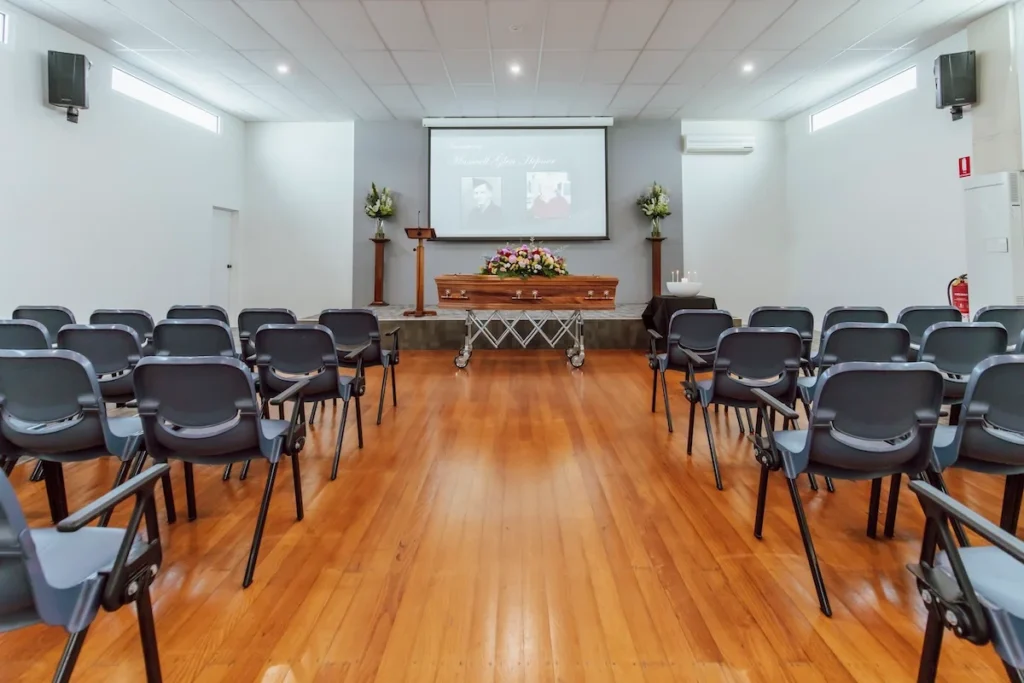 Wide interior view of polished timber floors and flexible seating facing the stage inside the East Geelong Uniting Hall, available through Jonathan Hepner Funerals at 199 Ormond Rd, East Geelong.