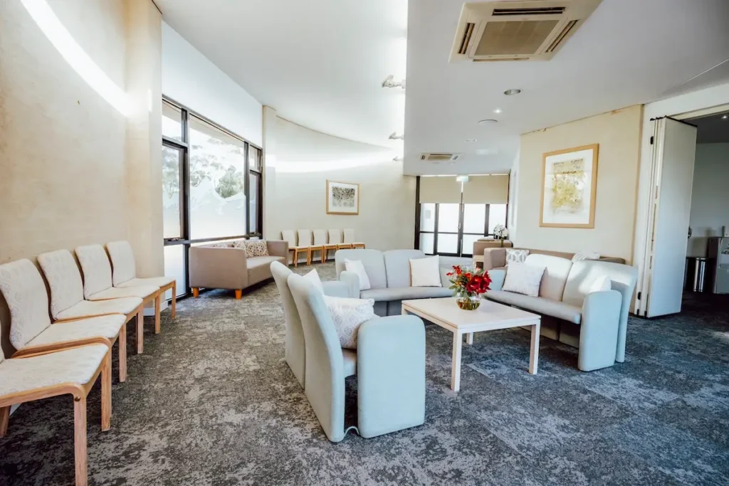 Modern family waiting lounge with comfortable grey sofas and coffee table setting inside Geelong Memorial Park Chapel, Mount Duneed.